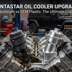 Side-by-side comparison on a 3.6L Pentastar V6 engine showing a cracked, leaking OEM plastic oil cooler housing versus a durable machined aluminum upgrade, with a black Jeep Wrangler Rubicon in a workshop background